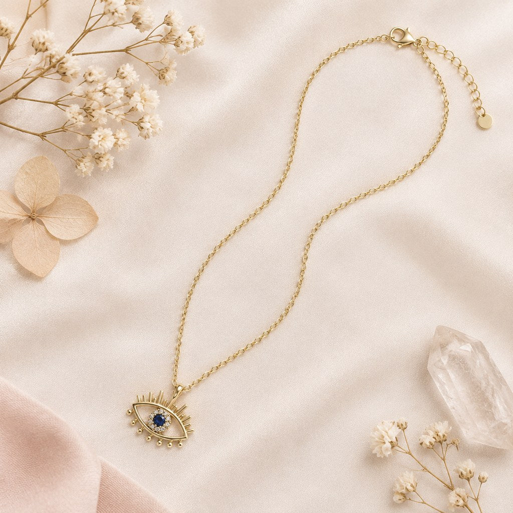 Gold Evil Eye Lash Necklace – Flat lay of 14K gold-plated brass cable chain and openwork eye pendant