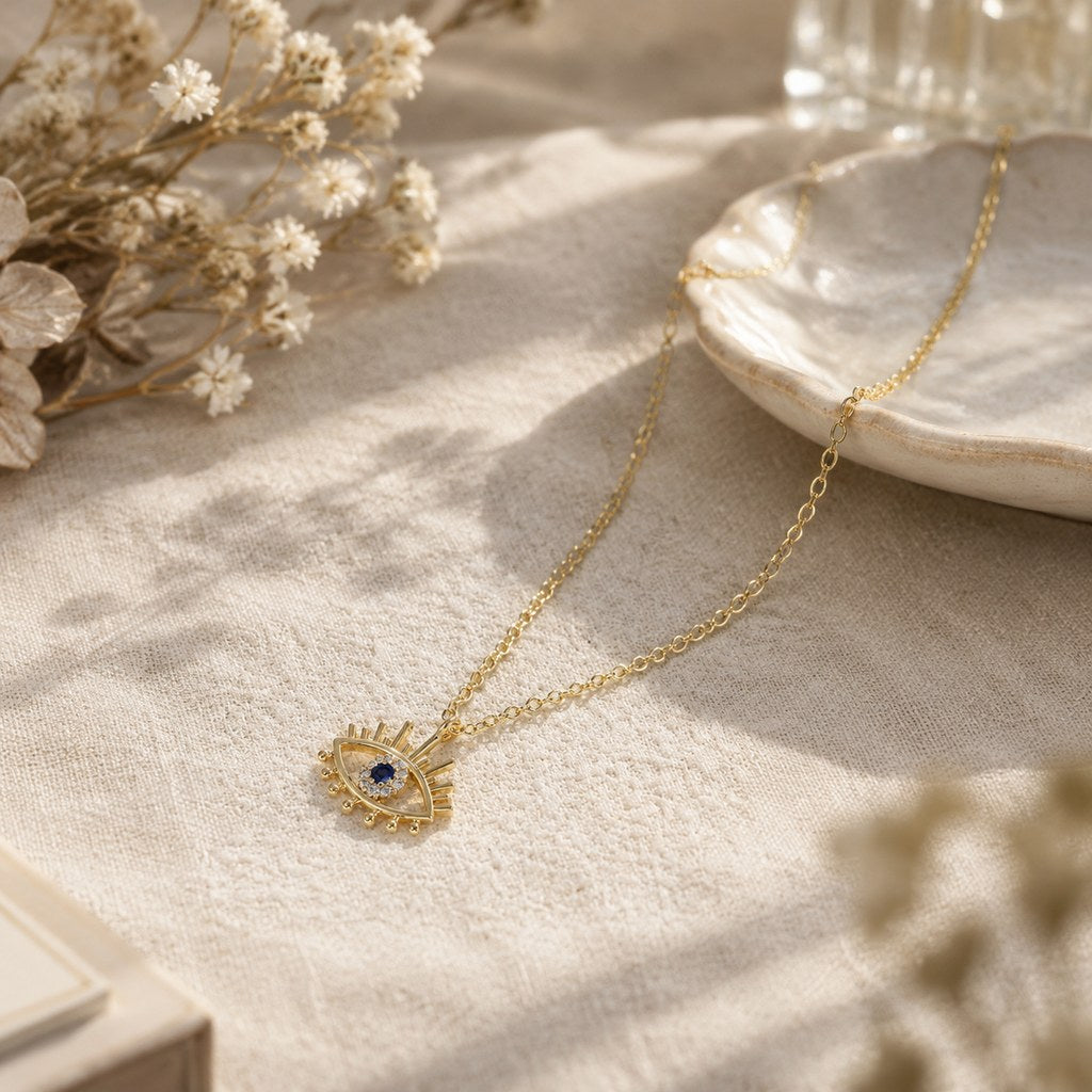 Gold Evil Eye Lash Necklace – Linen table styling with dried flowers and gold evil-eye lash pendant