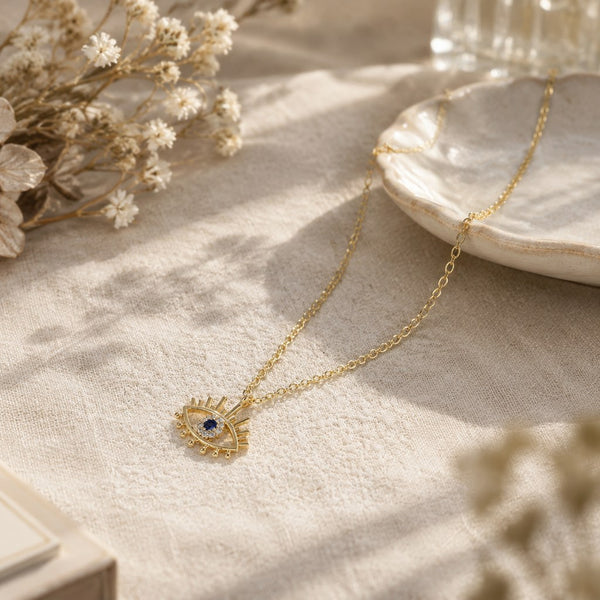 Gold Evil Eye Lash Necklace – Linen table styling with dried flowers and gold evil-eye lash pendant