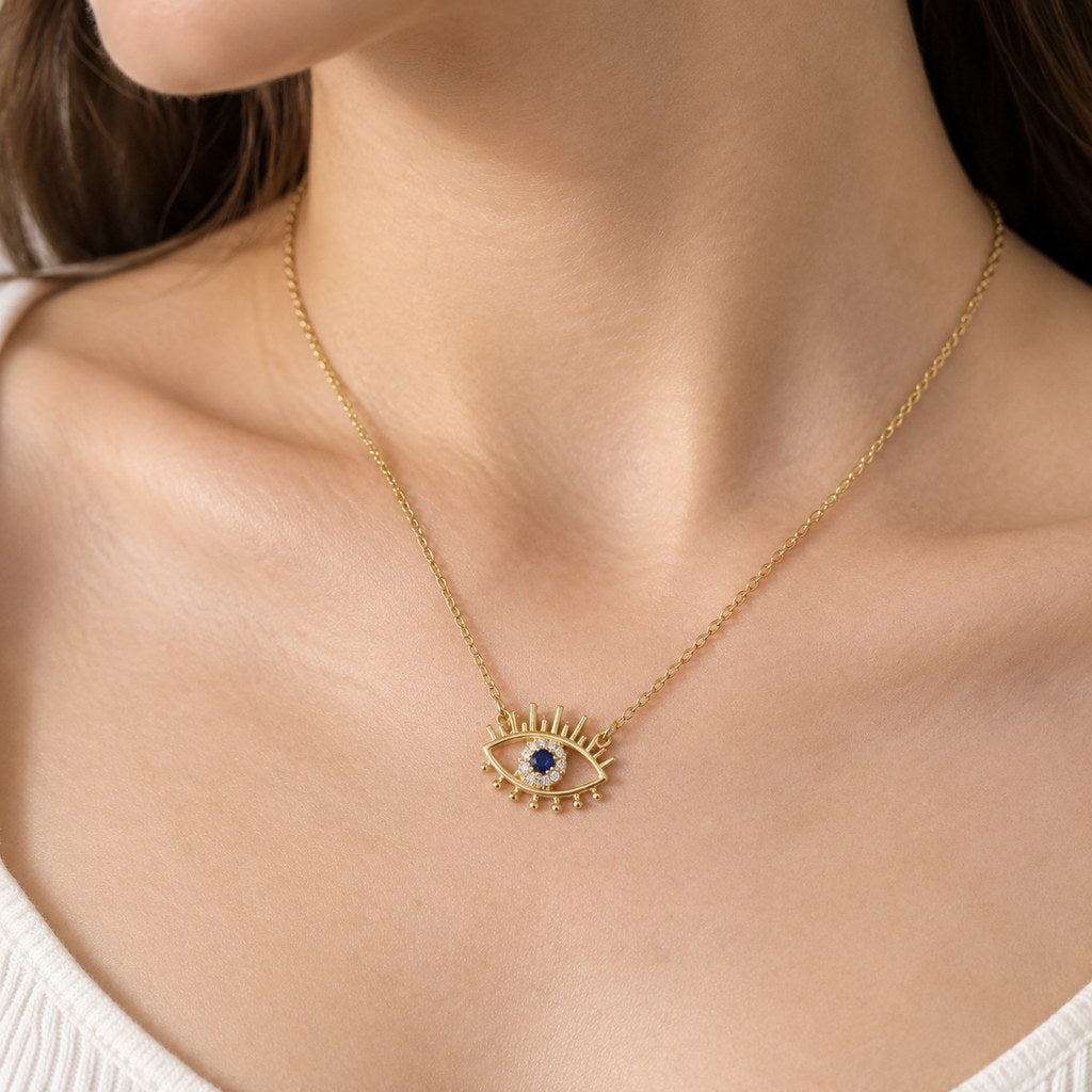 Gold Evil Eye Lash Necklace – Neck close-up of cable links, bail and blue stone in a white CZ halo