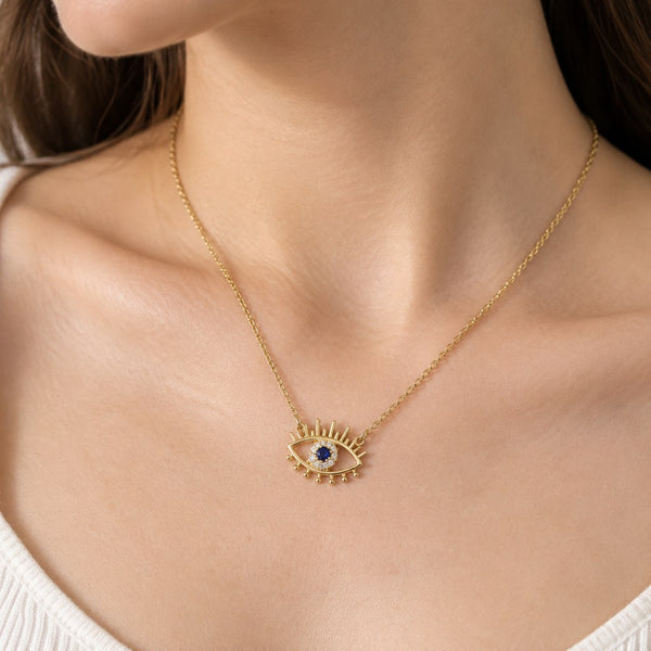 Gold Evil Eye Lash Necklace – Neck close-up of cable links, bail and blue stone in a white CZ halo