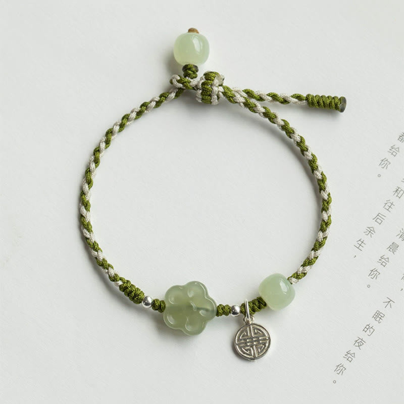 Plum Blossom Jade Flower Braided Bracelet – Olive green white twisted cord with pale jade flower bead and silver shou charm on white background, top-down flat lay