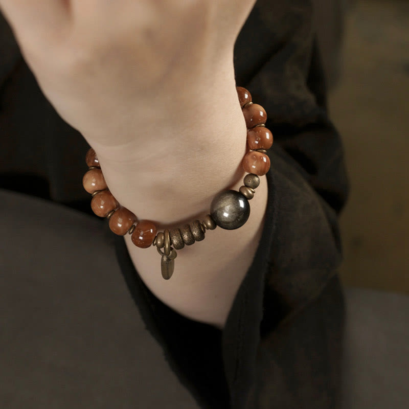 Tiger Eye Obsidian Wealth Bracelet – Brown beads with dark gunmetal sphere worn on wrist, bohemian style lifestyle photo