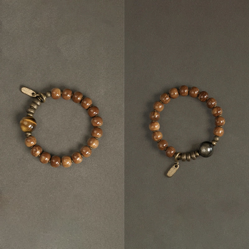 Tiger Eye Obsidian Wealth Bracelet – Two brown bead bracelets with tiger's eye and dark metallic accent stones on muted gray background