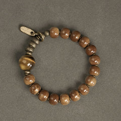 Tiger Eye Obsidian Wealth Bracelet – Caramel-brown beads with large tiger's eye stone and vintage brass toggle clasp on gray surface