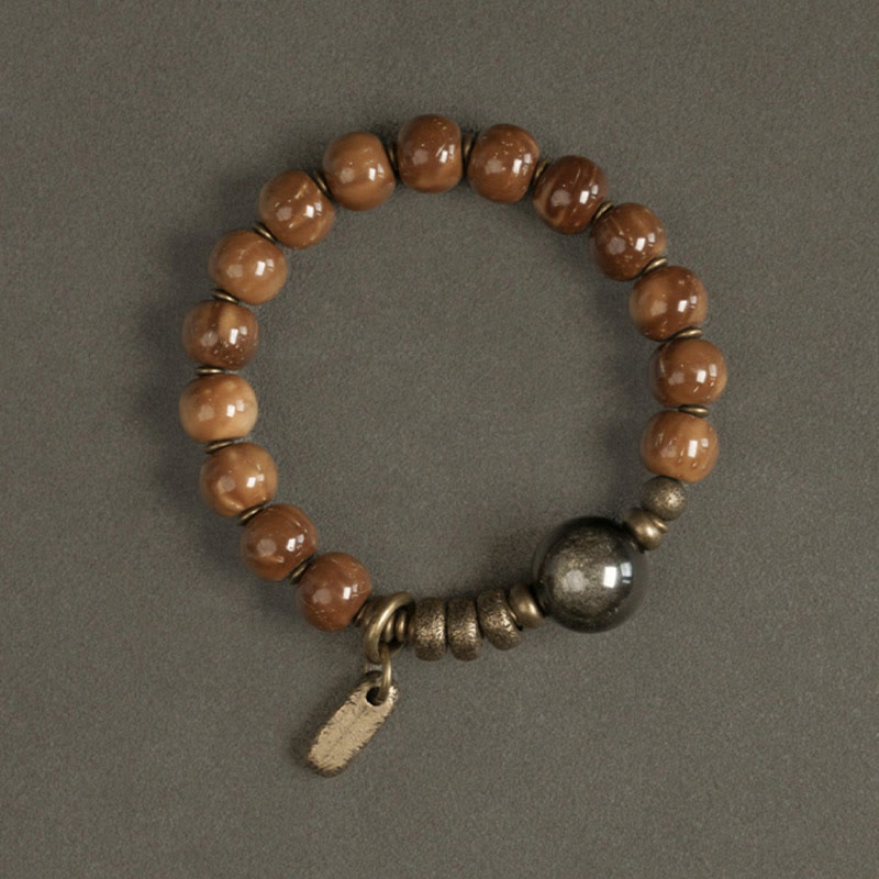 Tiger Eye Obsidian Wealth Bracelet – Caramel beads with dark gunmetal sphere accent and brass stacked rings on gray background