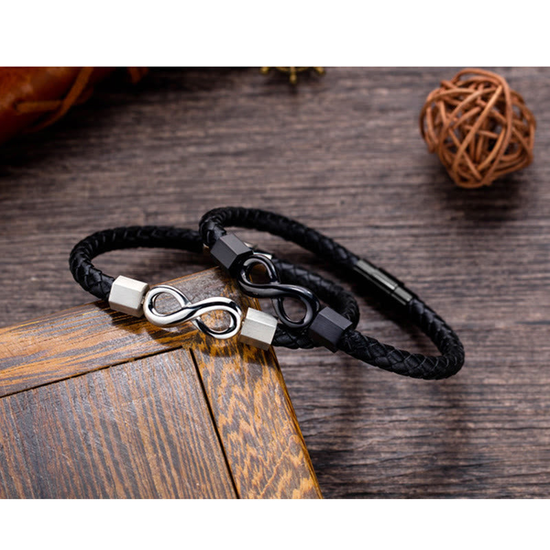 Endless Knot Titanium Steel Leather Bracelet – Two leather bracelets with silver and black infinity clasps on dark wood with rattan ball and box, rustic pair