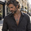 Men's Triangle Evil Eye Necklace – Bearded model wearing the pendant on a city street in a gray shirt, street style