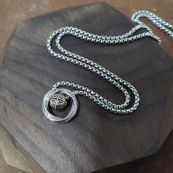 Full Mobius pendant necklace with box chain arranged on a dark wood surface