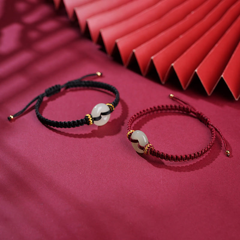 Peace Buckle Jade Abundance Bracelet – Two adjustable cord bracelets in black and burgundy with pale green jade ring pendants and gold beads, crimson fabric 45-degree