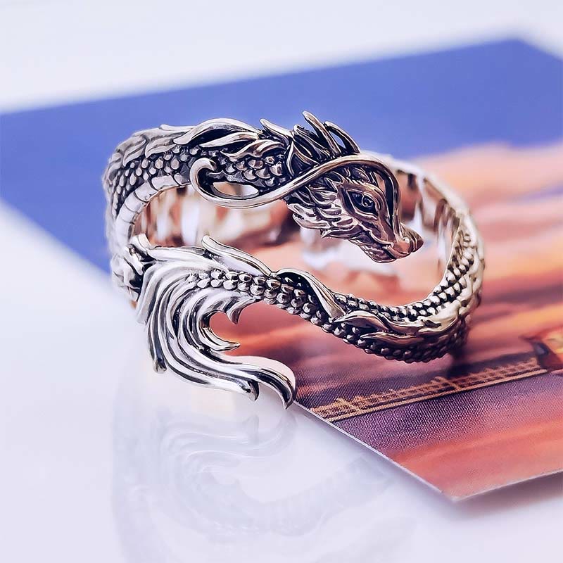 Vintage Dragon Pattern Silver Ring – Silver dragon ring with intricate scales and fierce serpentine head, blue orange printed background, three-quarter side angle
