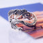 Vintage Dragon Pattern Silver Ring – Silver dragon ring with intricate scales and fierce serpentine head, blue orange printed background, three-quarter side angle