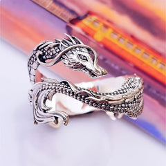 Vintage Dragon Pattern Silver Ring – Silver dragon ring with detailed scales and flame-like tail, colorful gradient background with filmstrip accents, three-quarter angle