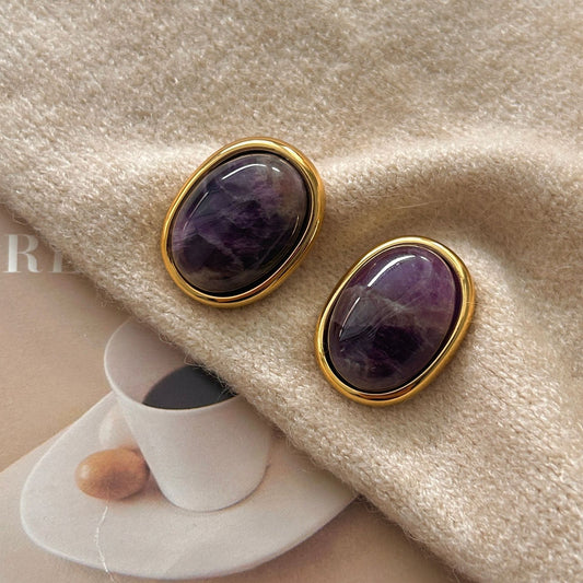 Amethyst Stud Earrings – oval purple amethyst cabochons in gold bezel setting on cream knit sweater with magazine props, crystal earrings