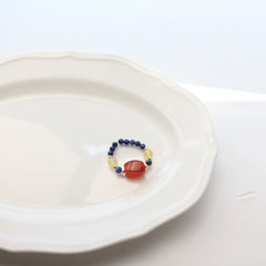 Lapis Lazuli Agate Ring Set – blue lapis bead ring with barrel-cut red agate and gold spacers on white plate, balance crystal jewelry