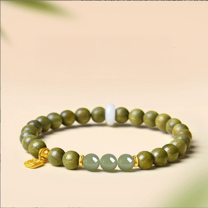 Green Sandalwood Bracelet – Single wrap with green Hetian jade and gold lock charm on beige, natural wood