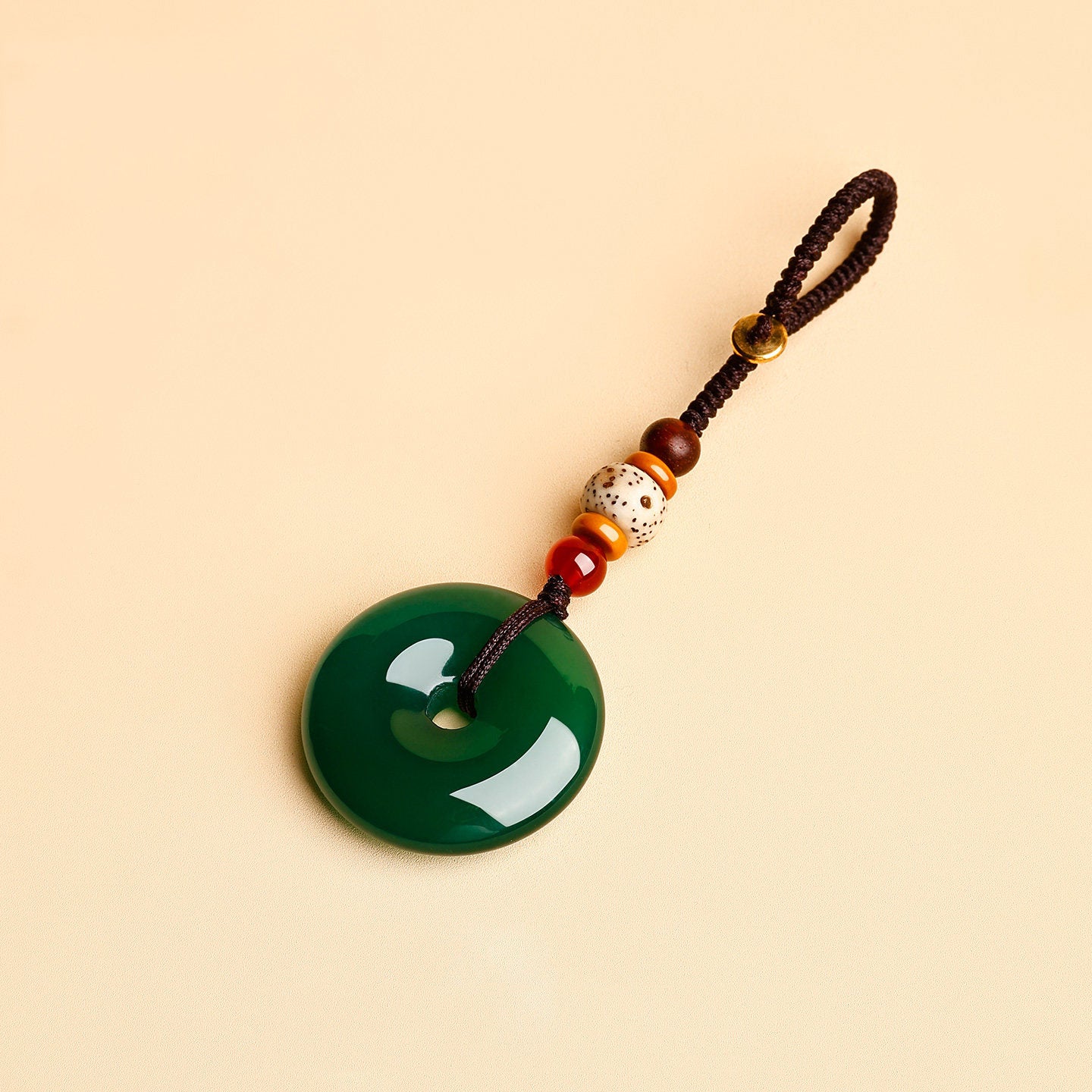 Jade Keychain Pendant – Green jade donut pendant with brown rope and red agate accents on beige, wealth keychain