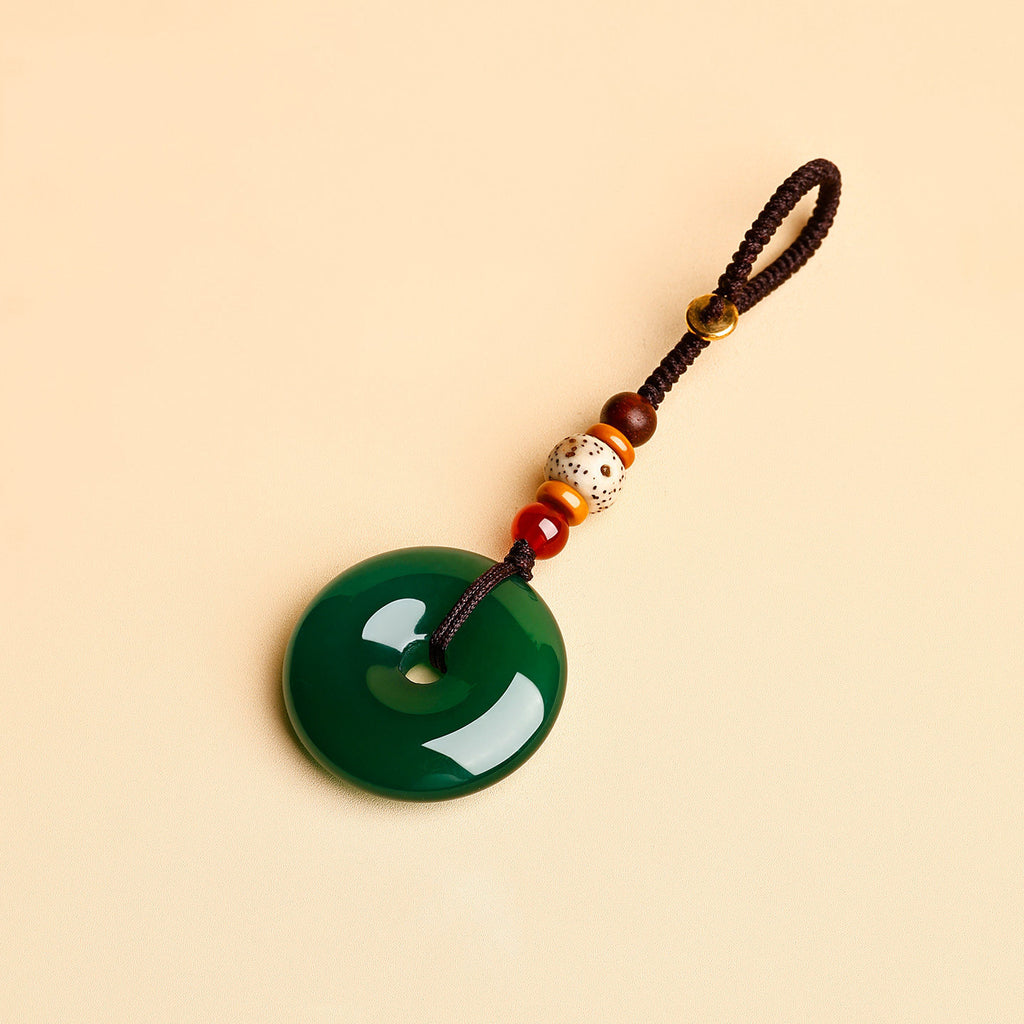 Jade Keychain Pendant – Green jade donut pendant with brown rope and red agate accents on beige, wealth keychain