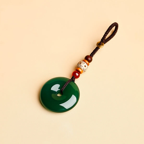 Jade Keychain Pendant – Green jade donut pendant with brown rope and red agate accents on beige, wealth keychain