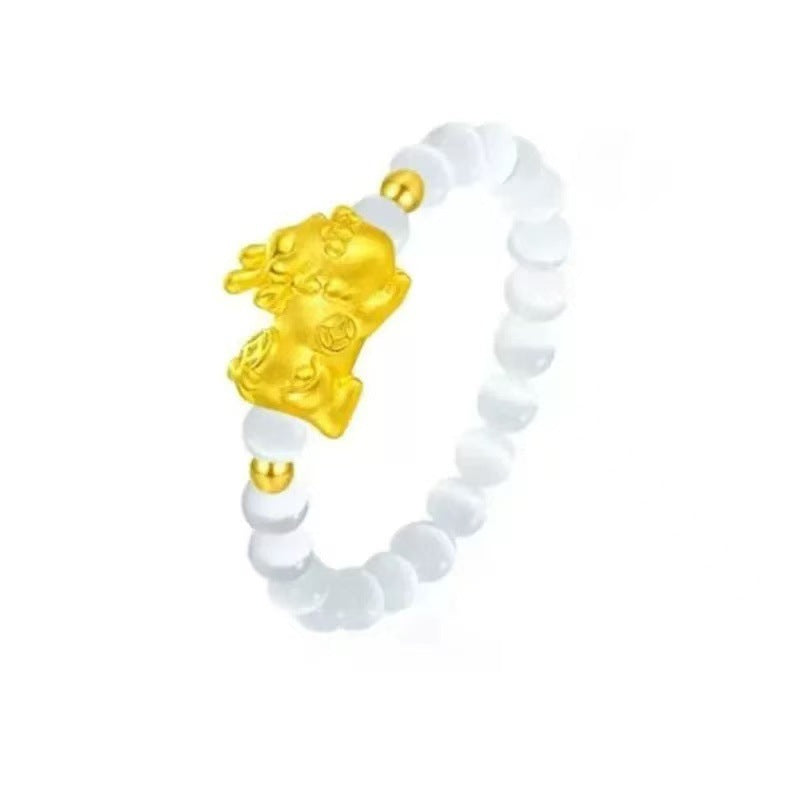 Cat's Eye Pi Xiu Ring – White cat's eye bead ring with gold Pi Xiu charm isolated on white, wealth ring