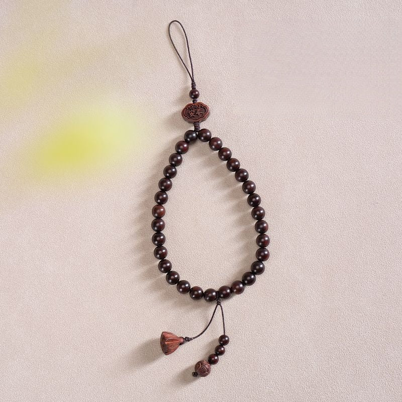 Zodiac Wood Bead Lanyard – Dark red beaded phone strap with lotus and tassel pendant on textured background, elegant zen lanyard