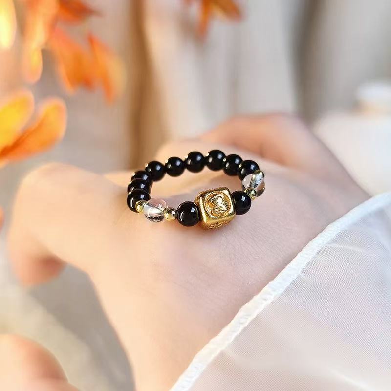 Obsidian Lucky Cat Ring – Black bead ring with gold Maneki-neko charm worn on hand, fortune jewelry
