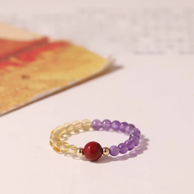 Amethyst Cinnabar Ring – Purple amethyst bead ring with red cinnabar center and gold spacers on light background