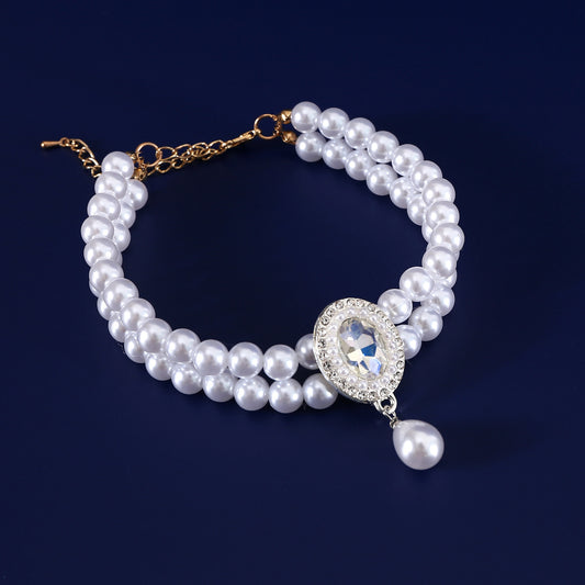 Luxury Pearl Pet Necklace – Double-layer pearl collar with clear crystal centerpiece and teardrop pendant, navy backdrop