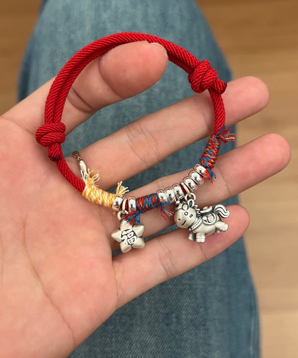 Horse Red String Bracelet – Red cord with silver horse charm and fortune star, hand held over jeans, zodiac