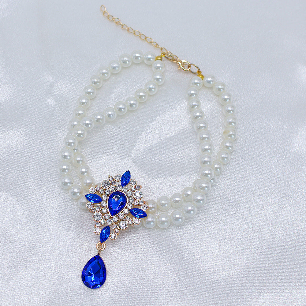 Elegant Pearl Crystal Collar – Double-layer pearl collar with blue teardrop crystal centerpiece, white satin