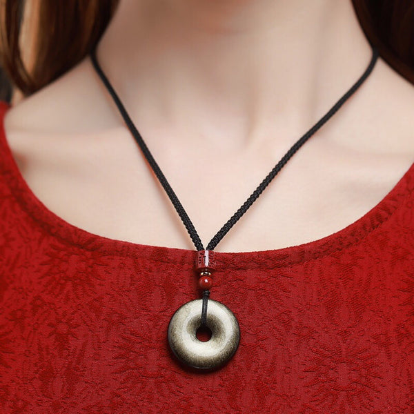Gold Obsidian Pendant – Gold sheen obsidian necklace worn on black cord with red cinnabar bead, courage amulet