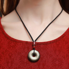 Gold Obsidian Pendant – Gold sheen obsidian necklace worn on black cord with red cinnabar bead, courage amulet