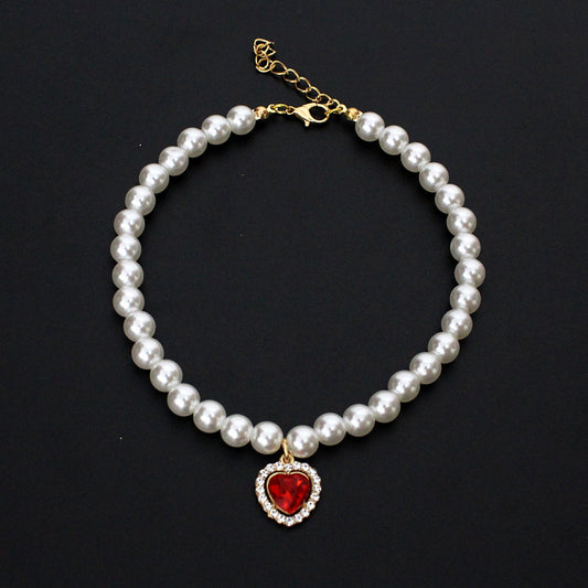 Crystal Heart Pet Necklace – Single strand pearl collar with red heart rhinestone pendant on black background
