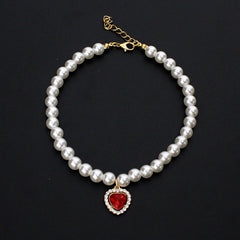 Crystal Heart Pet Necklace – Single strand pearl collar with red heart rhinestone pendant on black background