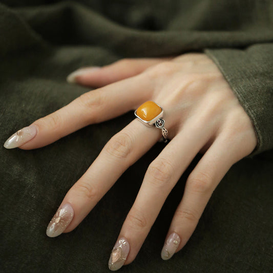 Honey Amber Sugar Cube Ring – Square amber gemstone in silver band on finger with green fabric, adjustable cocktail