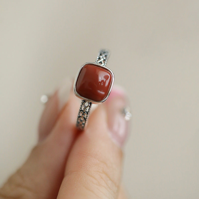 Red Agate Openwork Ring – square red agate sugar cube held between fingers on beige background, red agate ring