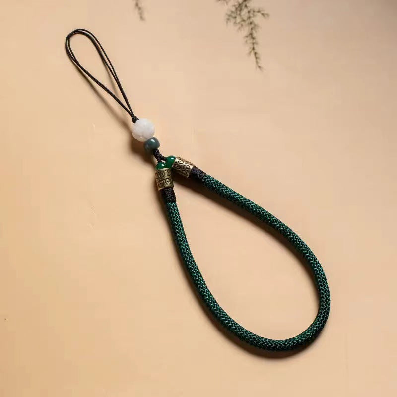 Lotus Bodhi Lanyard – Dark green braided lanyard with white lotus bodhi and ornate bronze beads, nature-inspired phone grip