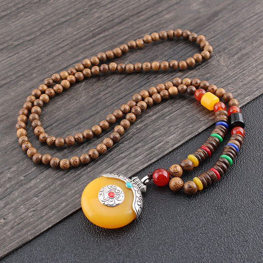 Wenge Mala Necklace – 108 wooden beads with yellow donut pendant in silver setting red accent, wood background