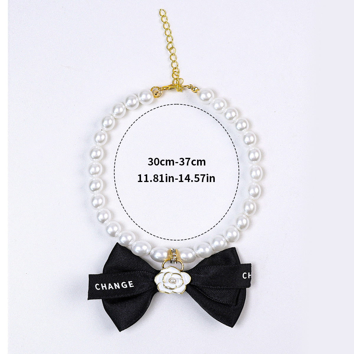 Luxury Crystal Pet Necklace – pearl collar with black bow and white enamel camellia charm, gold hardware, flat lay