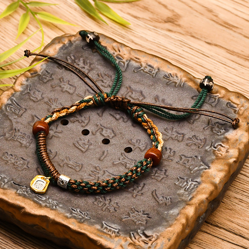 Tibetan Cord Bracelet – green woven cord with wood beads and gold pendant on stone, blessing bracelet