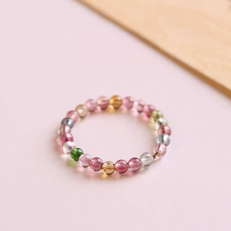 Tourmaline Ring – Multicolor tourmaline bead ring on pink surface with gold bead accent, rainbow gemstone ring