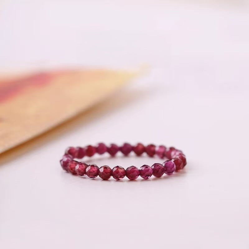 Garnet Ring – Faceted red garnet bead ring on light background with warm tones, passion energy jewelry