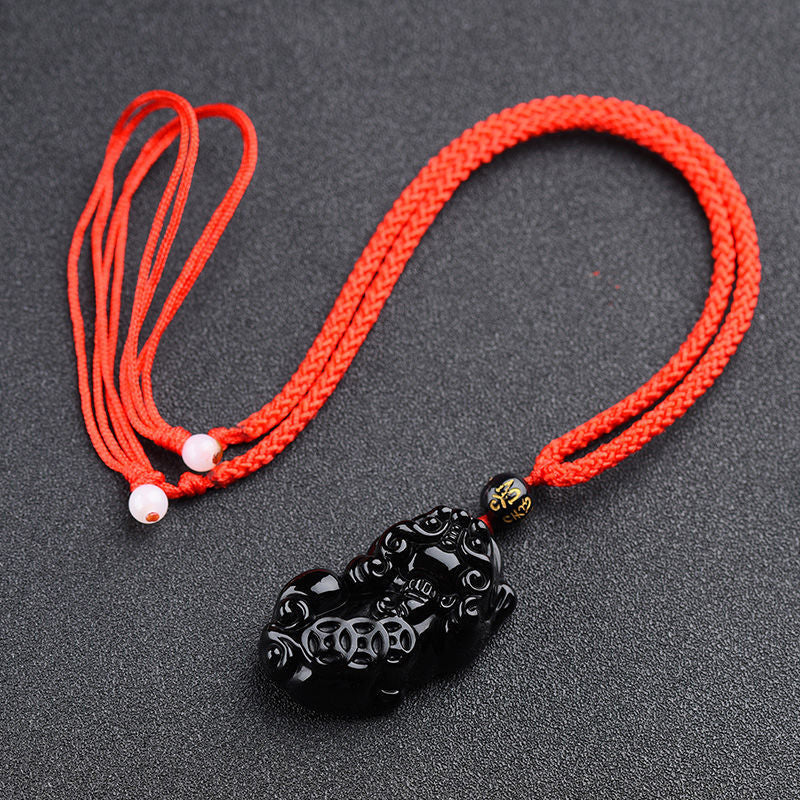 Obsidian Pixiu Necklace – Red braided cord with black obsidian pixiu charm, white bead adjusters on gray