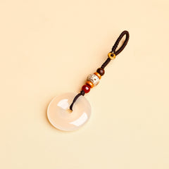 Jade Keychain Pendant – White jade donut pendant with braided rope and bodhi beads on beige background, feng shui