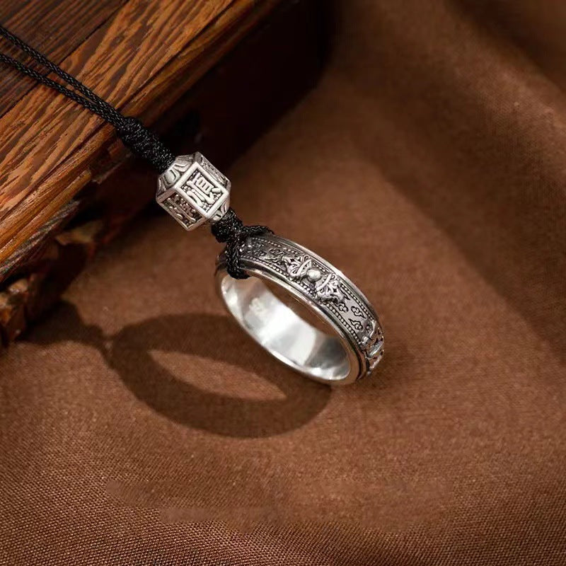 Mantra Phone Ring – side view of silver engraved ring band on brown fabric next to rustic wood