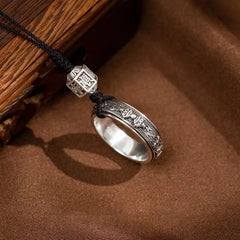 Mantra Phone Ring – side view of silver engraved ring band on brown fabric next to rustic wood