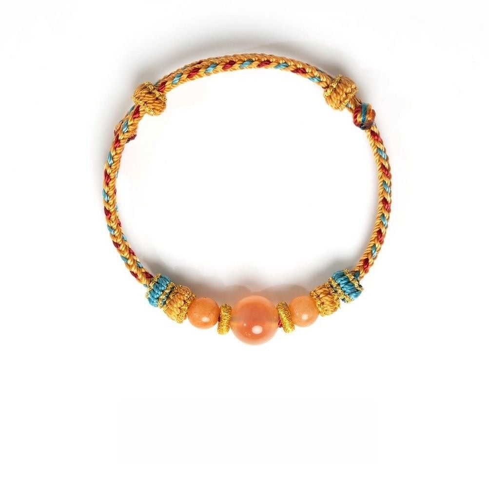 Dunhuang Agate Bracelet – golden braided cord bracelet with large peach moonstone center and blue knot details, fortune bracelet