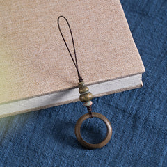Sandalwood Phone Grip – Green sandalwood ring grip with golden hued gourd bead on beige book, Zen anti-drop accessory