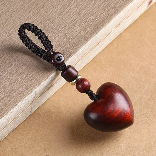 Rosewood Heart Keychain – carved heart with braided loop, wooden beads and brass ring on aged paper