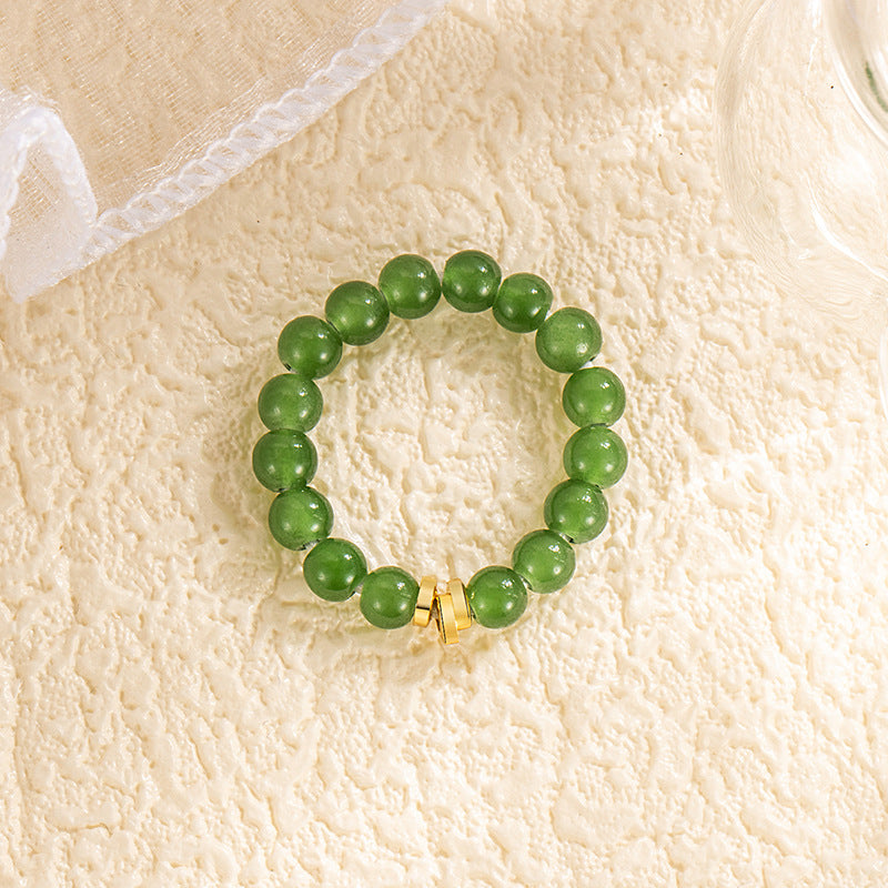 Jade Bead Ring – light green Hetian jade beads with gold barrel accent, cream textured surface, white lace fabric, minimalist feng shui